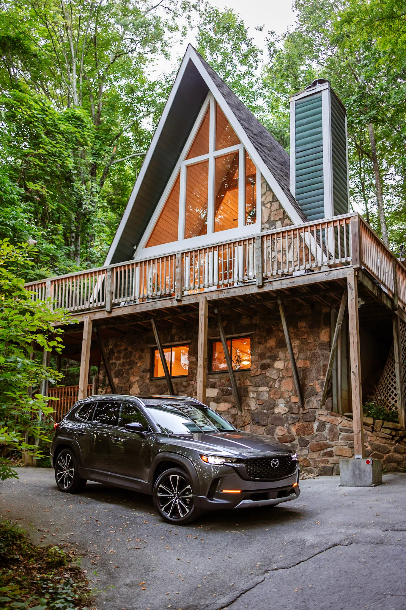 A-frame facade with driveway and car at Little Green Cabin