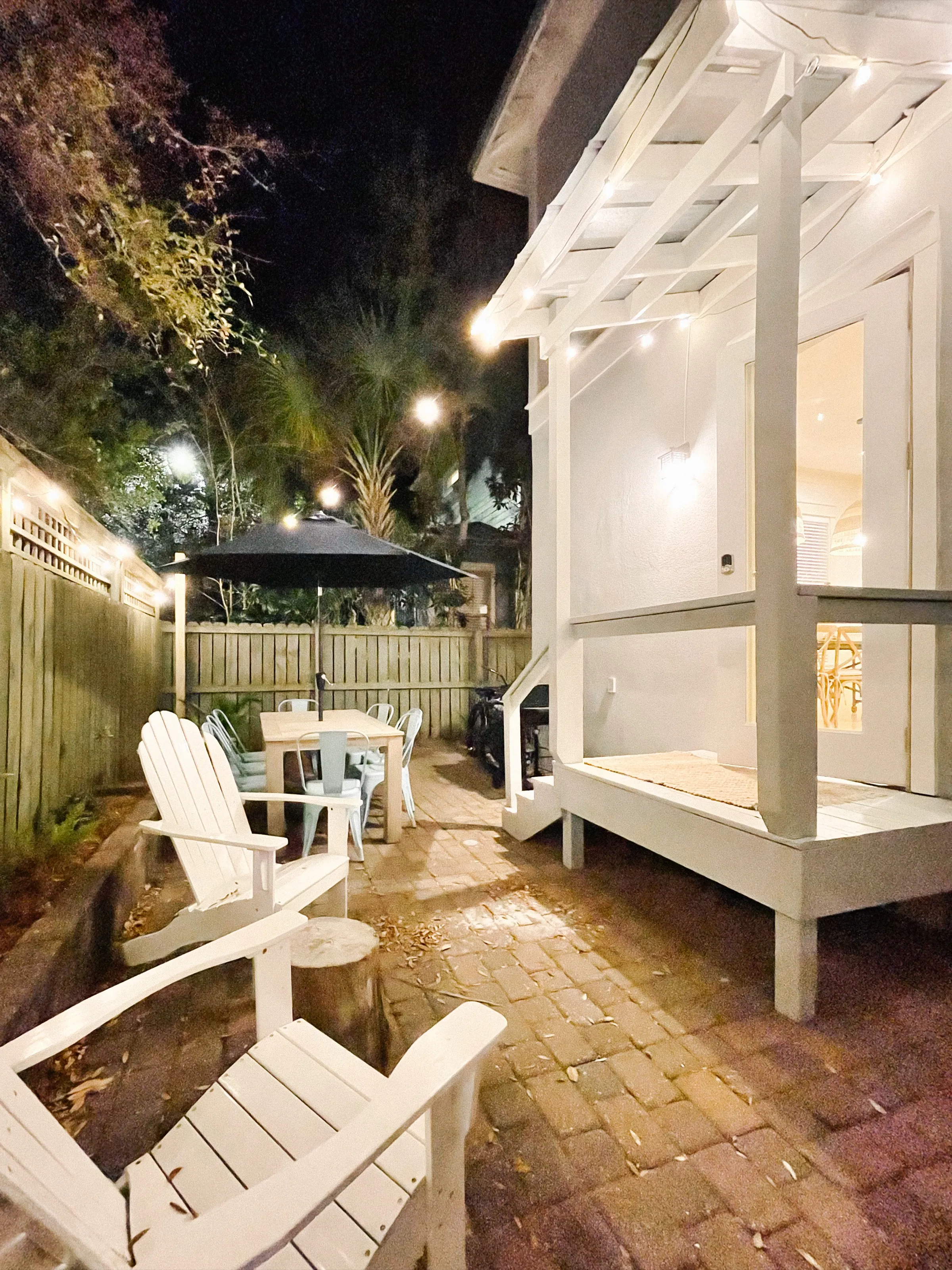 Porch with string lights at dusk at Sand Reef Cottage