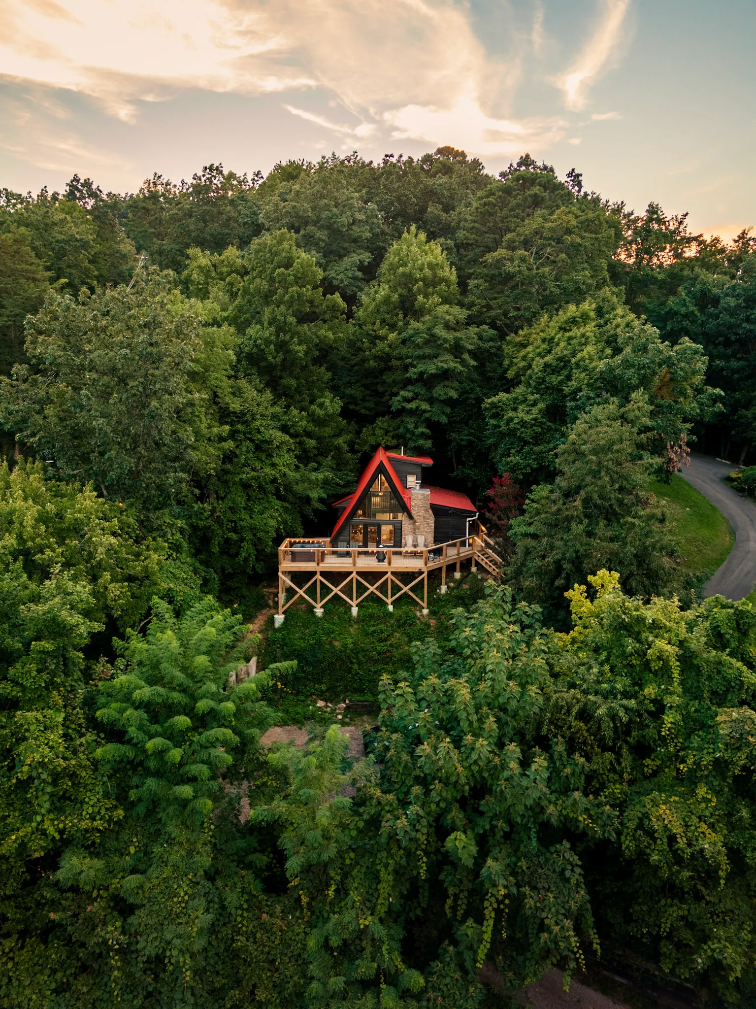 Aerial A-frame nestled in the treetops at golden hour at Après Chalet