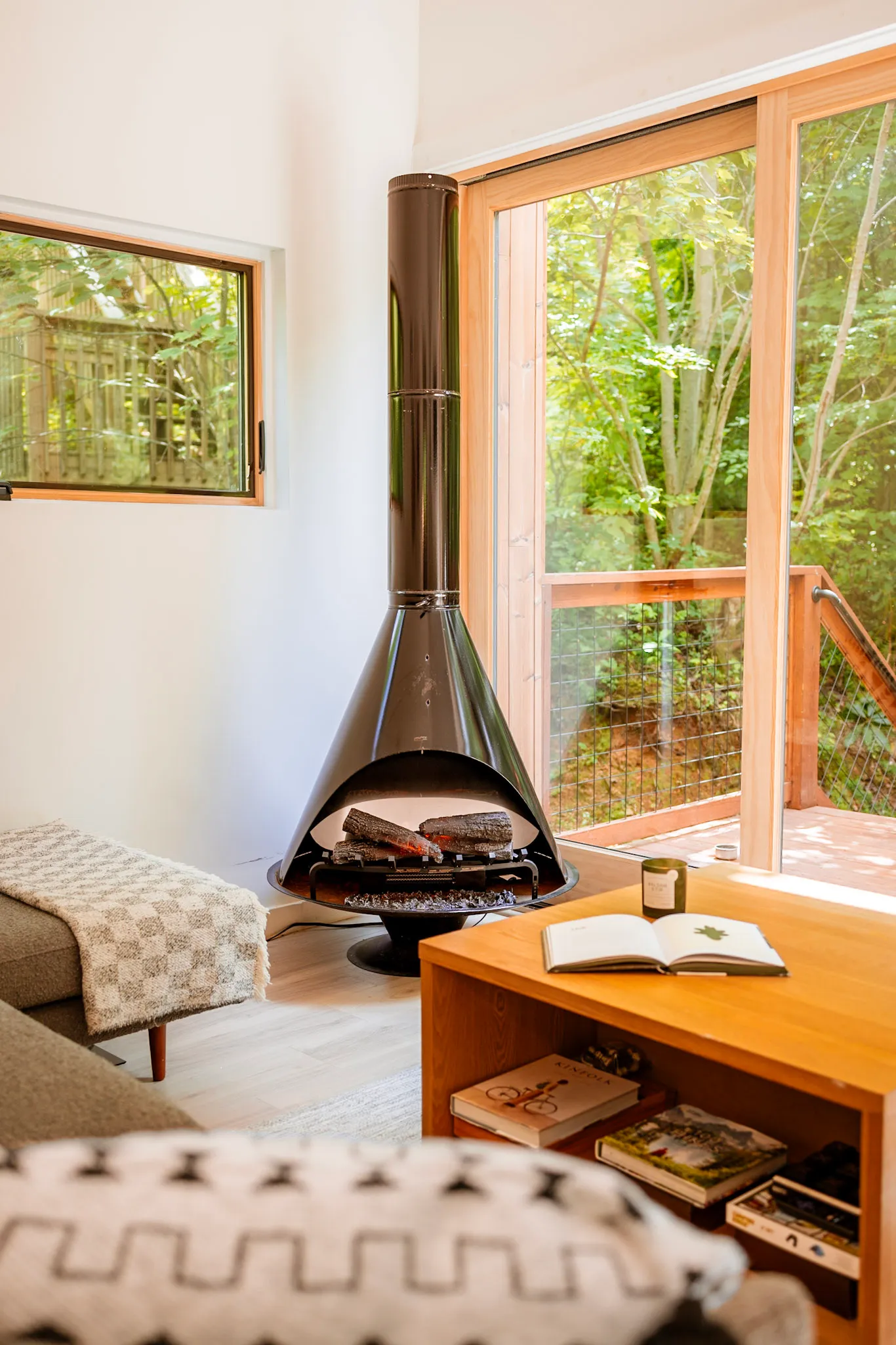 Cone fireplace lit with deck view through glass doors at Nordic Haus