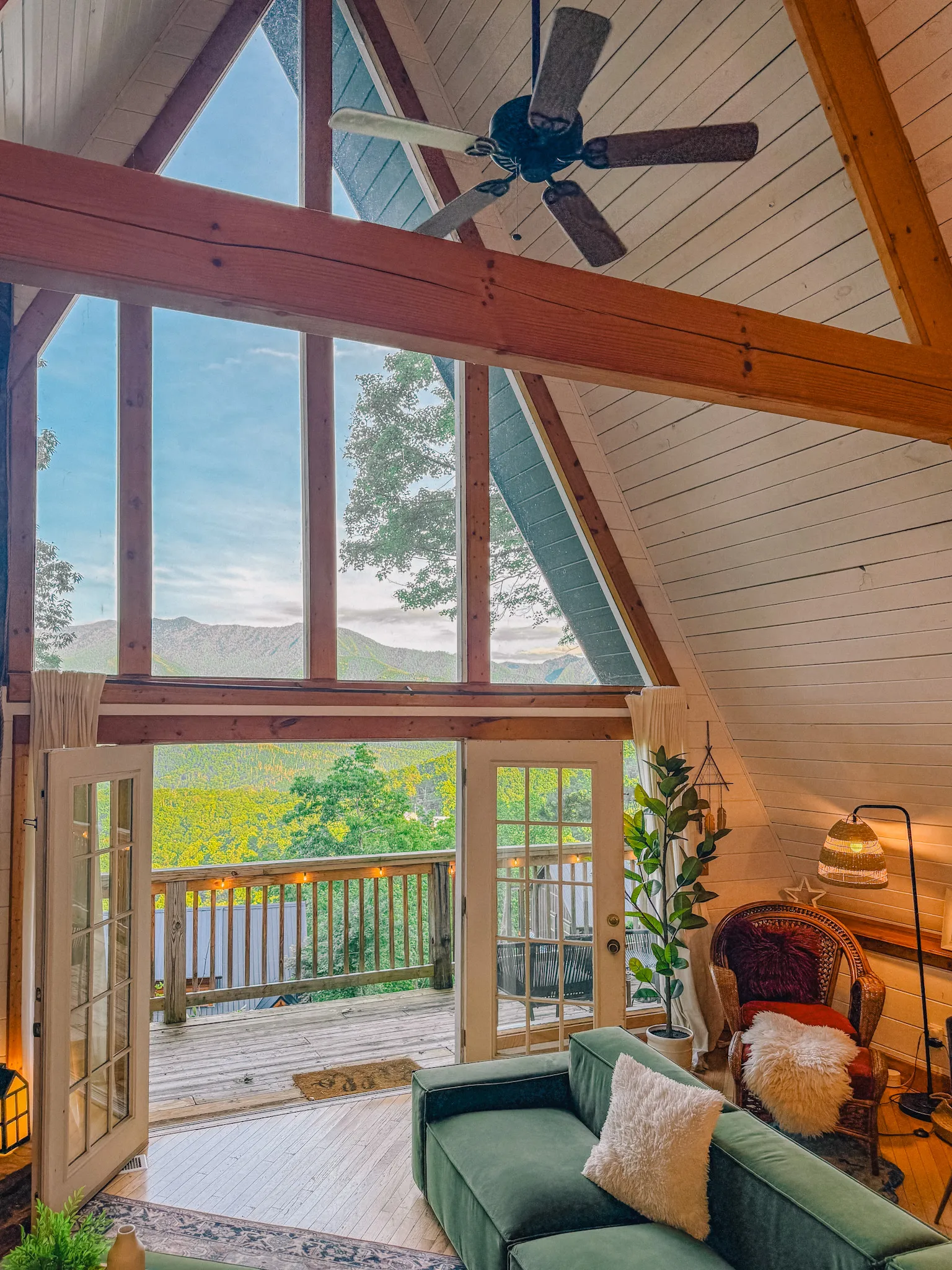 Vaulted living room with wall of windows and mountain view at Little Green Cabin