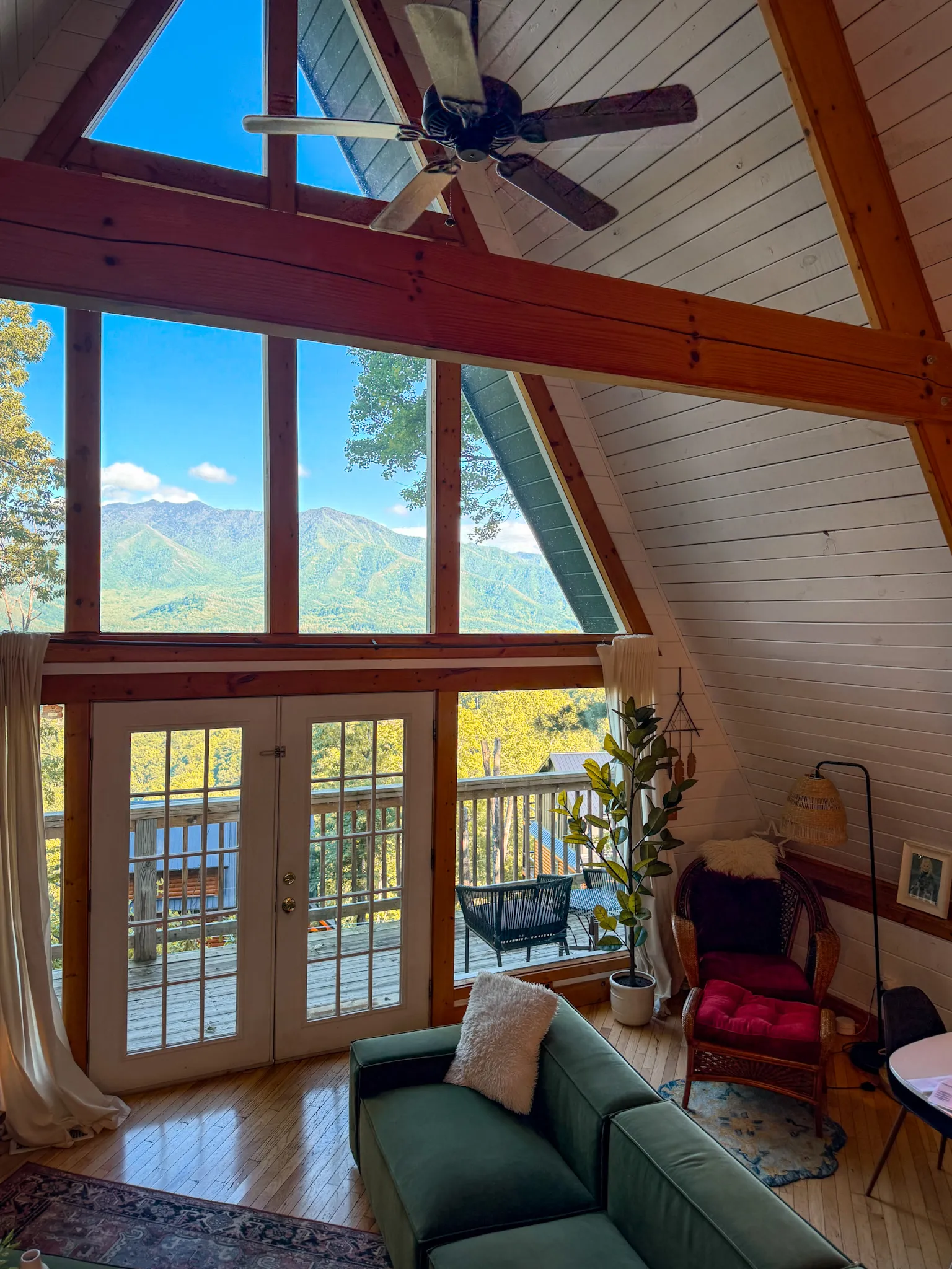 Living room sectional and mountain view in daylight at Little Green Cabin