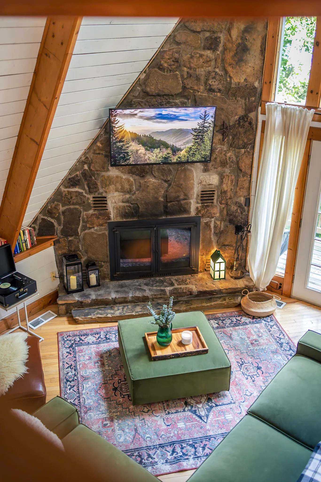 Stone fireplace lit in the living room at Little Green Cabin