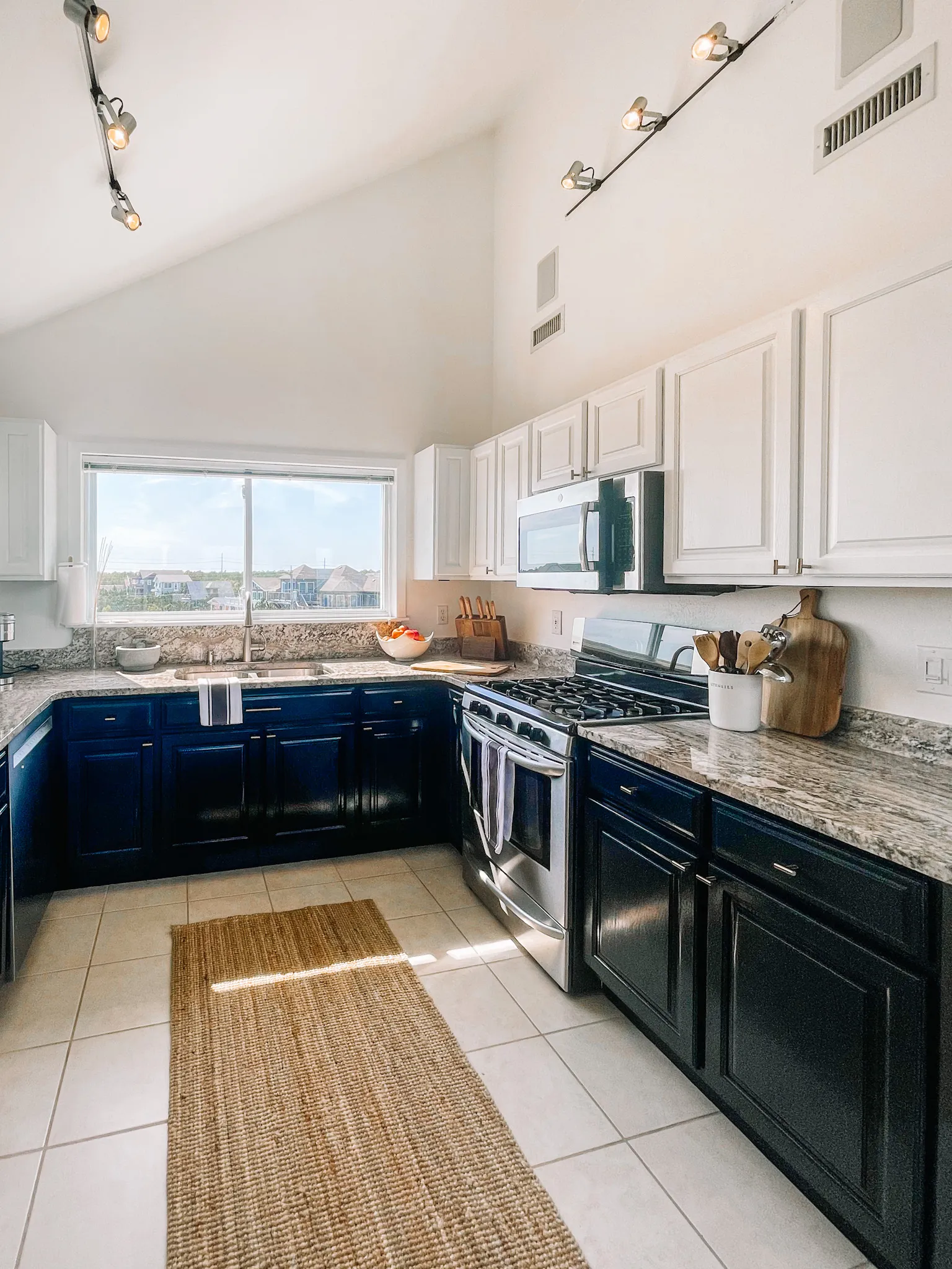 Kitchen with navy cabinets and gas range at Dune Haus