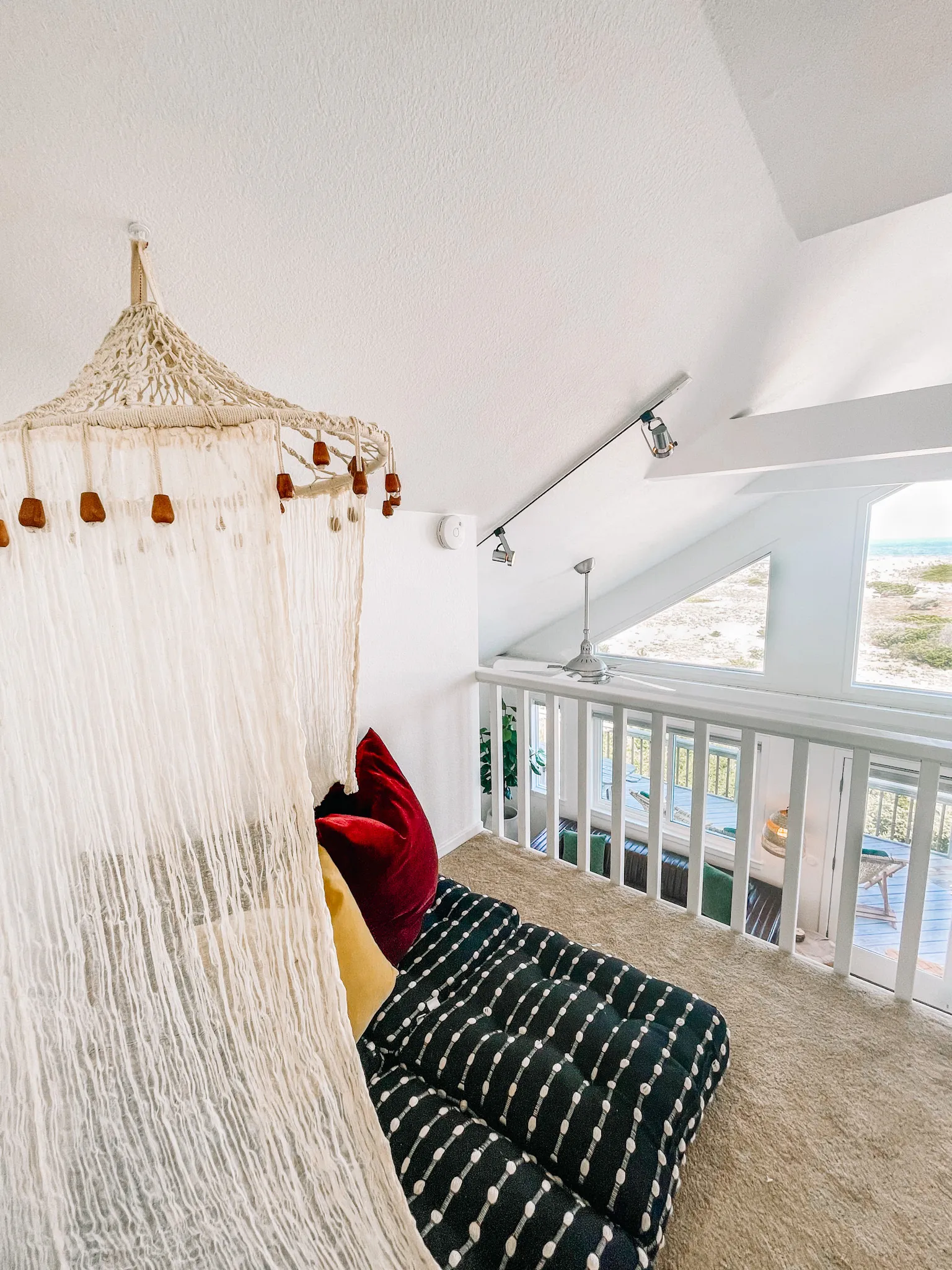 Loft nook with hanging canopy daybed at Dune Haus