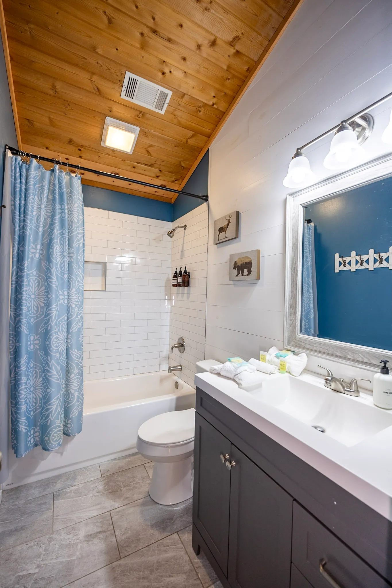 Bathroom one tub shower combo with navy wall at Hygge Blue Chalet