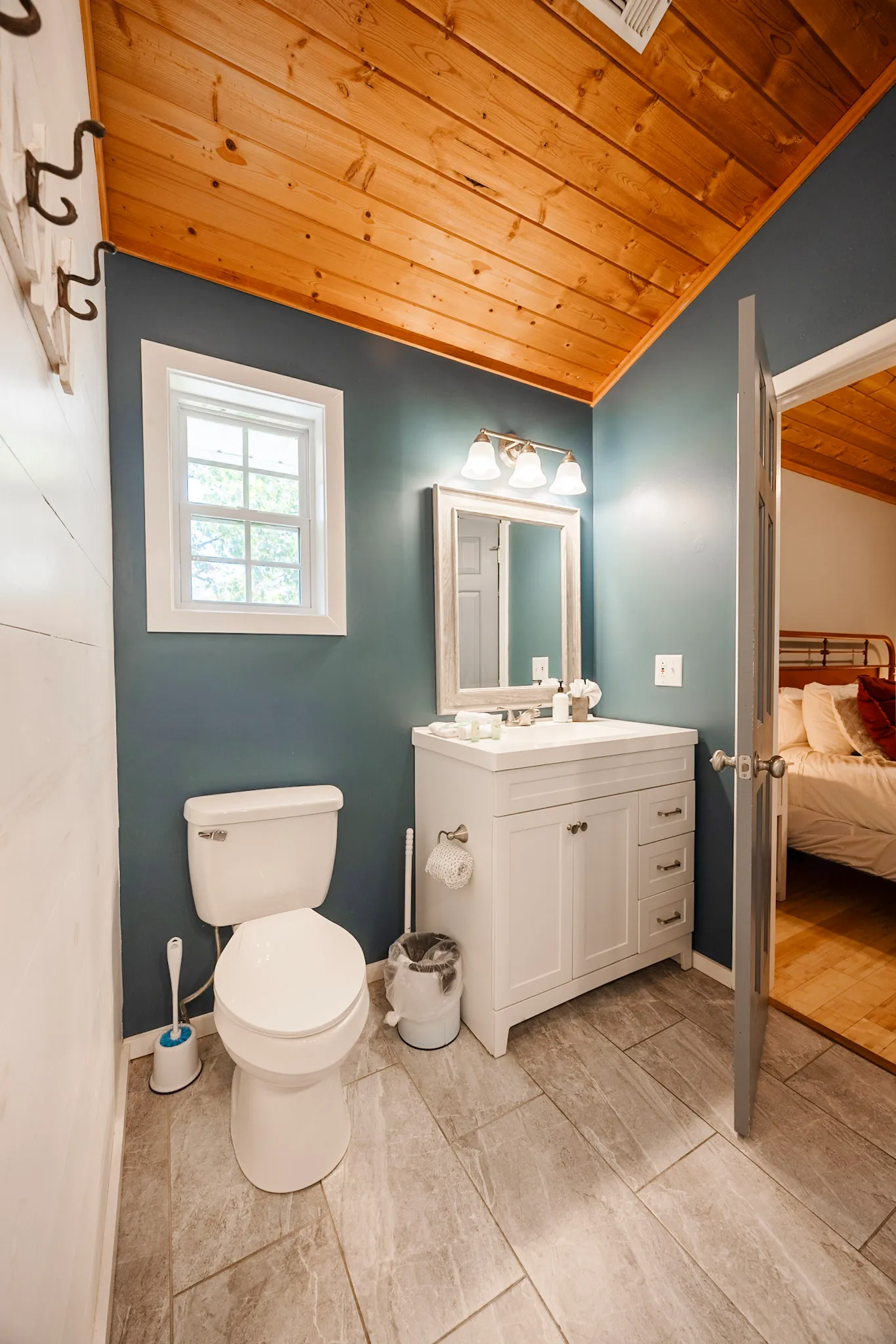 Bathroom one toilet and vanity with door to bedroom at Hygge Blue Chalet