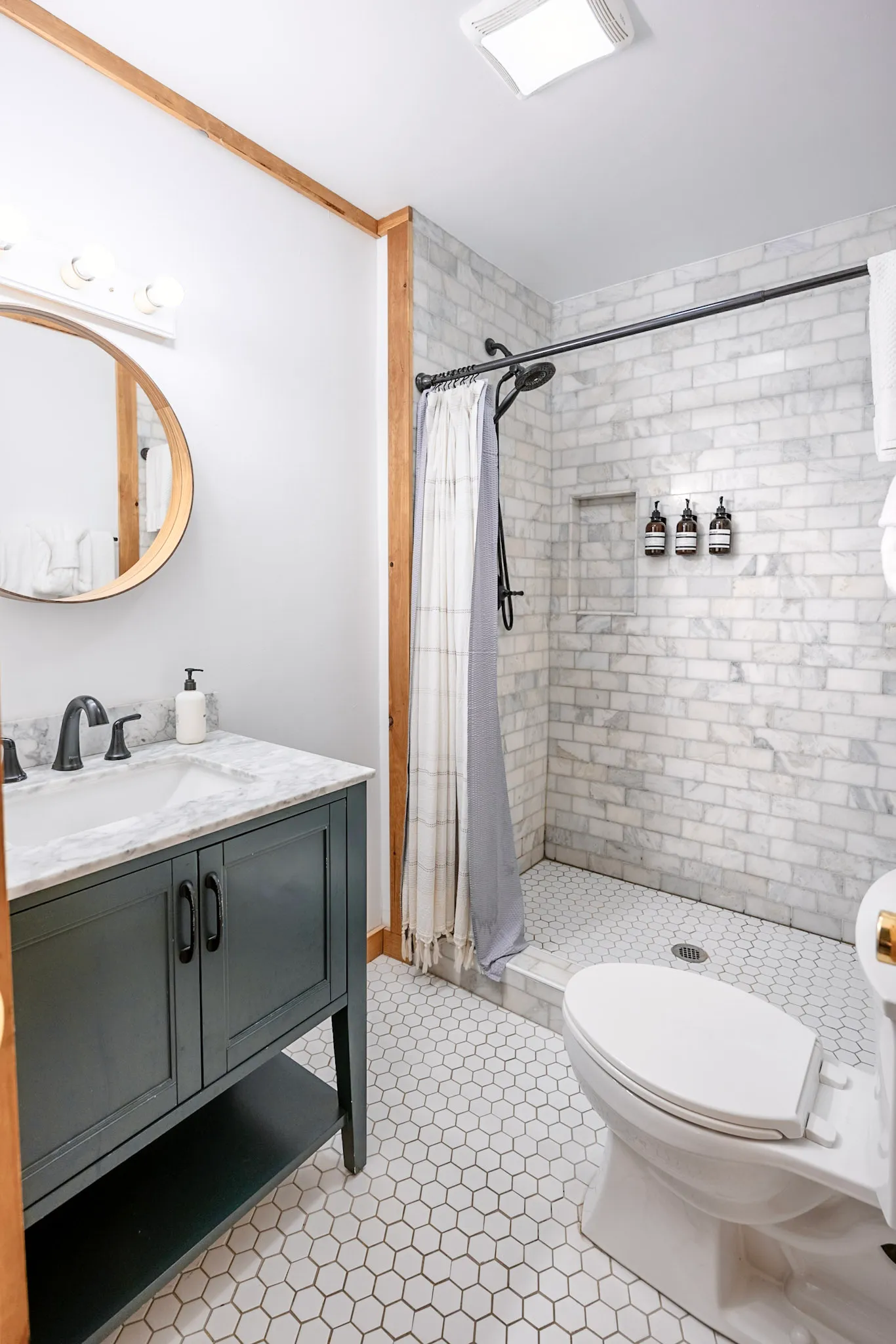 Bathroom with marble vanity and subway tile shower at Little Green Cabin