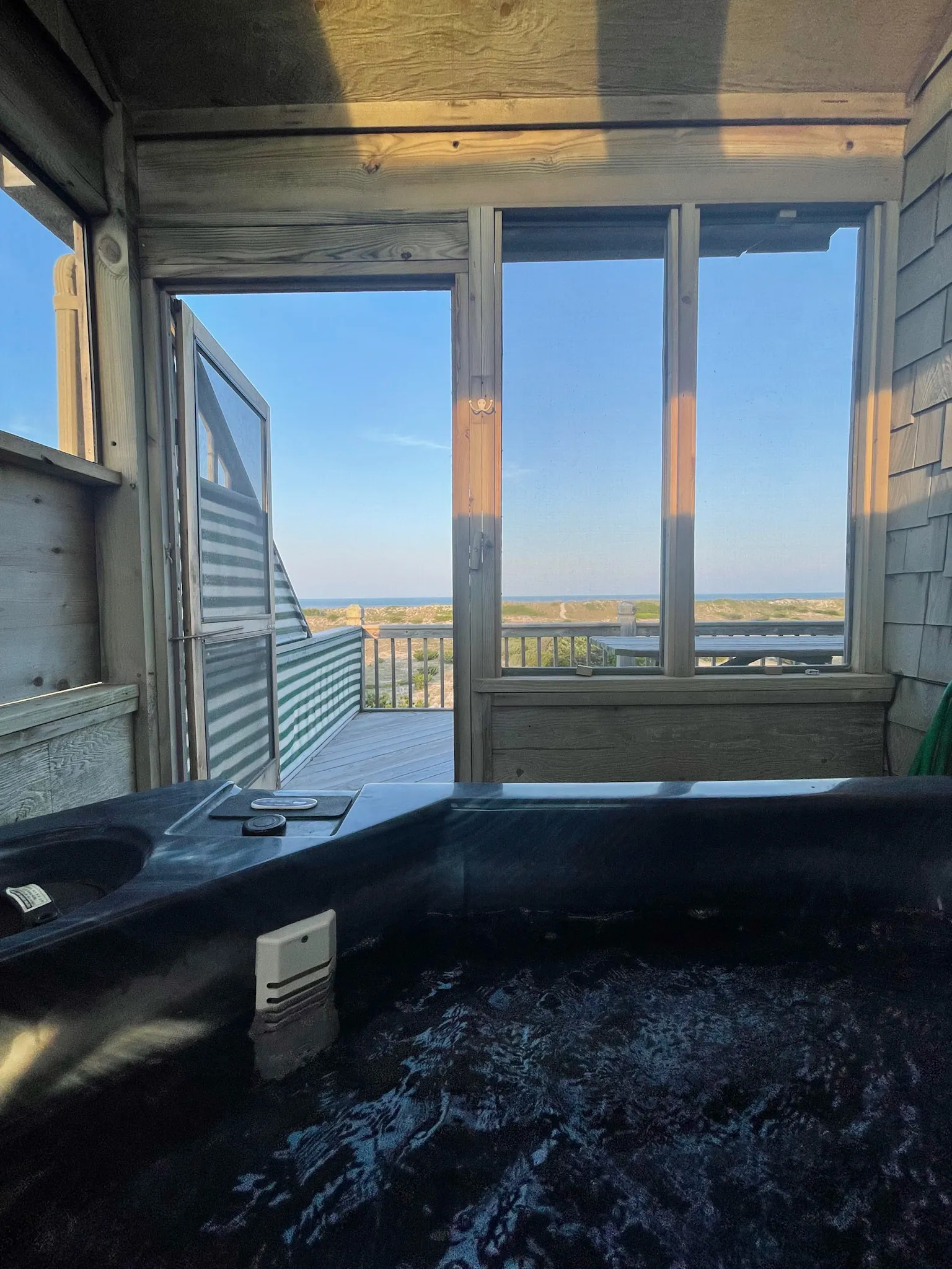 Hot tub on the screened porch by day at Dune Haus