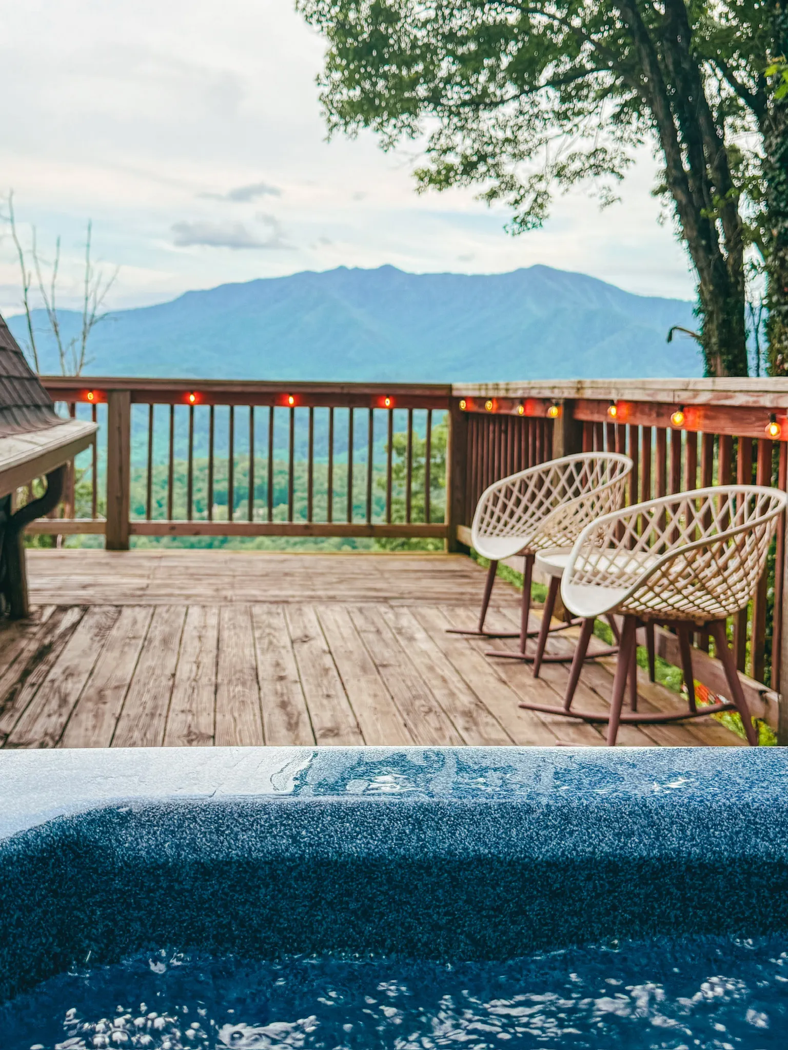 Hot tub on the deck with mountain view at Little Green Cabin