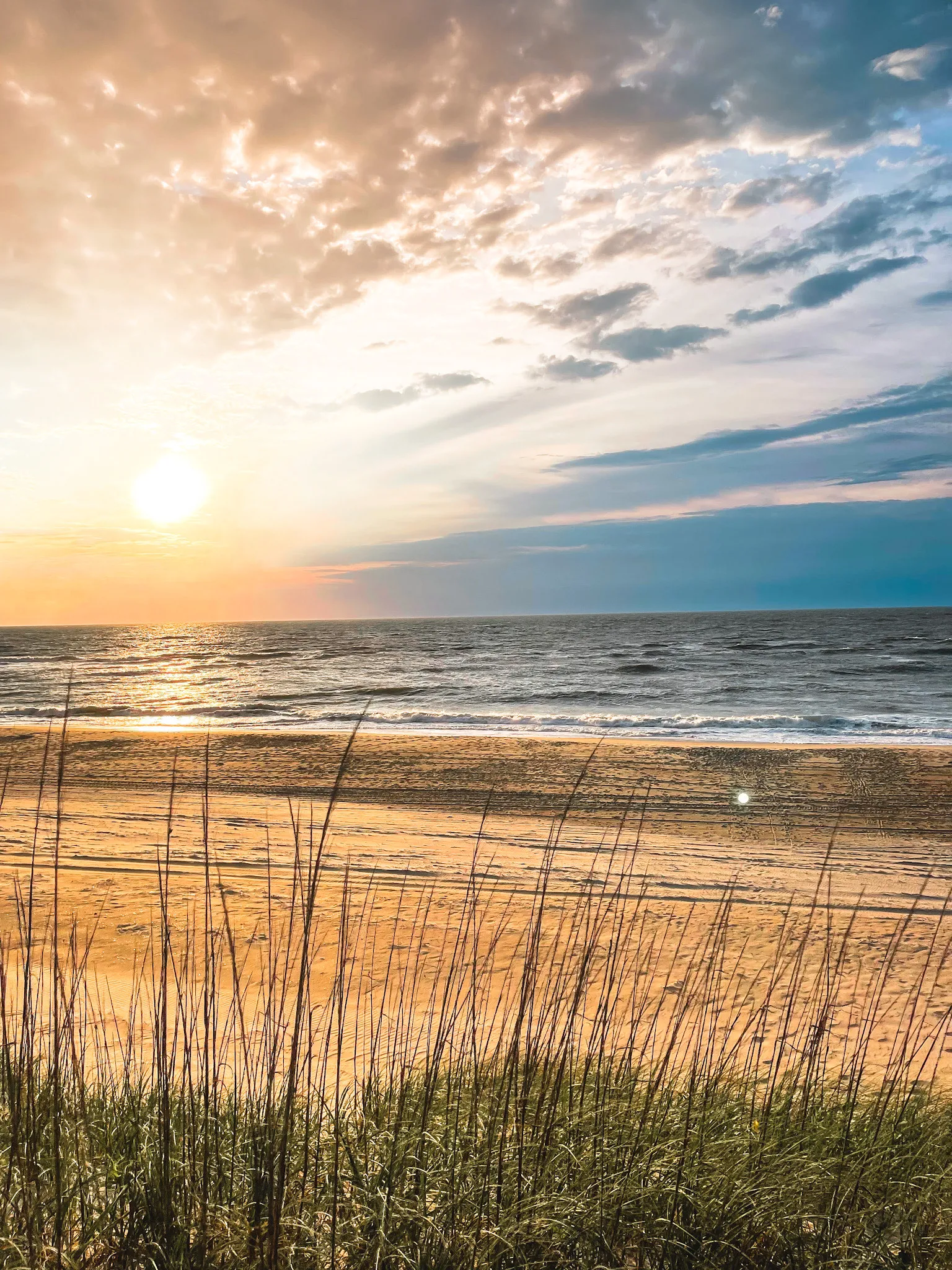 Sunrise over the beach through the sea oats at Dune Haus